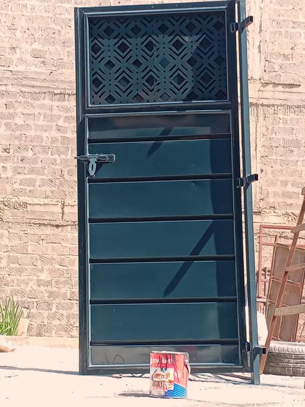 Modern black steel security door with decorative upper panel